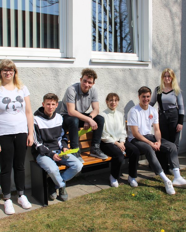 drei Mädchen und drei Jungen, die auf einer sonnigen Bank sitzen | © RÖSLE GROUP drei Mädchen und drei Jungen, die auf einer sonnigen Bank sitzen | © RÖSLE GROUP
