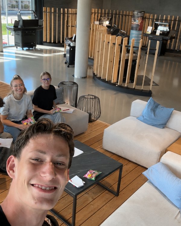 Drei Jungs und zwei Mädchen auf einem Sofa in Shop sitzen und in die Kamera lächeln | © RÖSLE GROUP