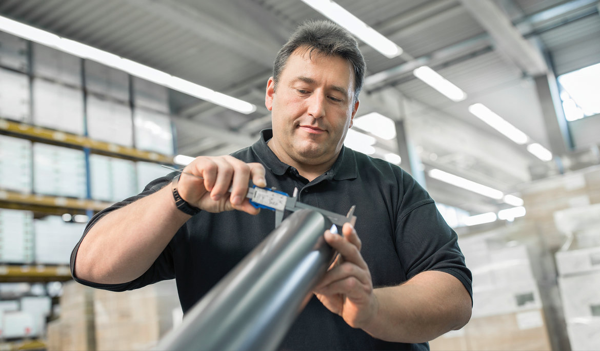 Employee measures a GRÖMO ALUSTAR rainwater downpipe | © GRÖMO